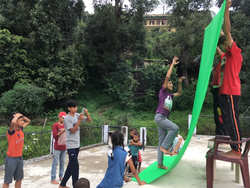 Young students in a village shooting a special effects scene with green screen
